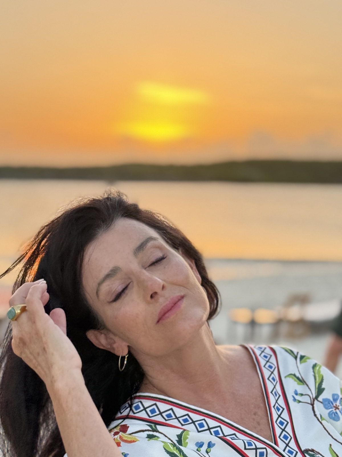Denise Jonas in a natural-light portrait at sunset over the water
